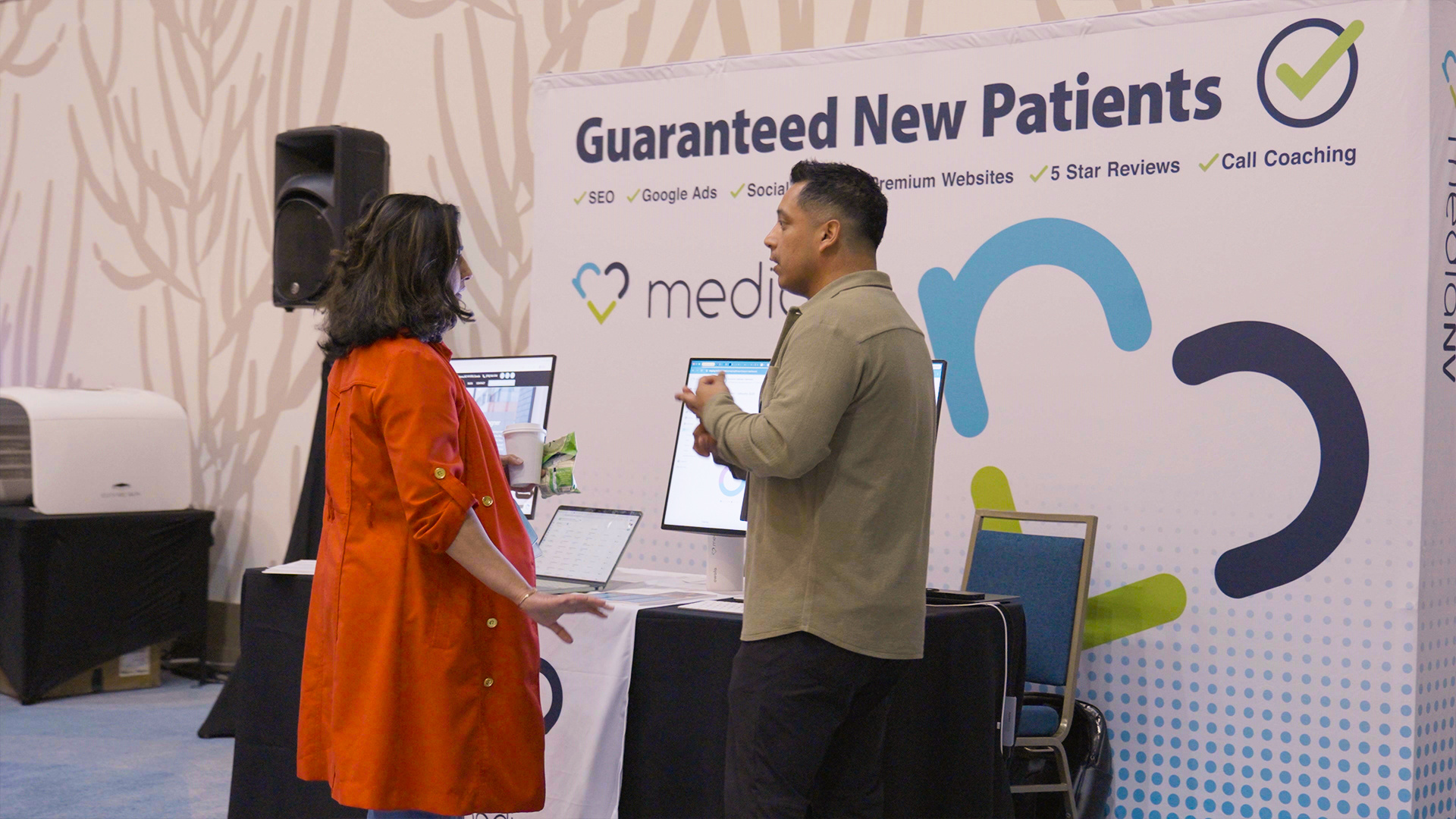 MediaNV team speaking with an attendee at the booth