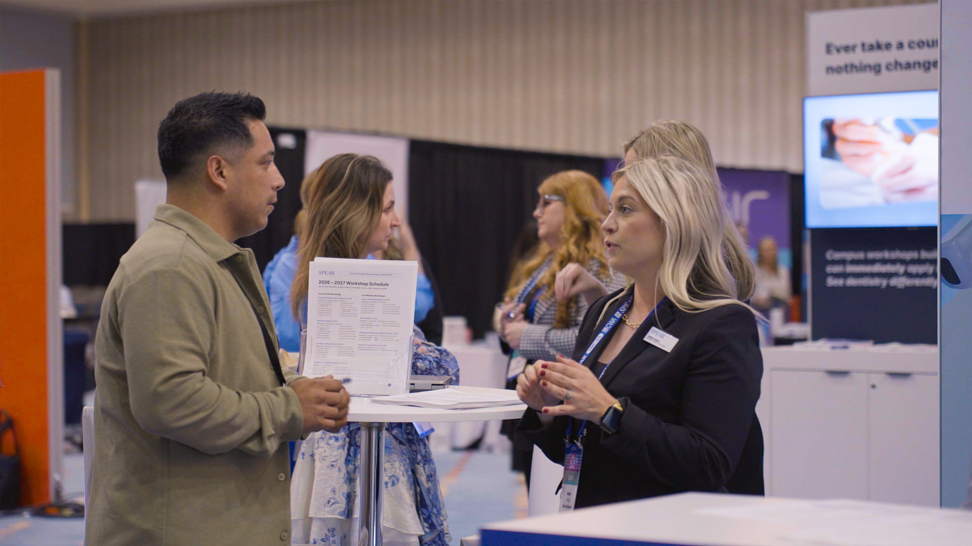 Attendees talking through a workshop schedule at the conference