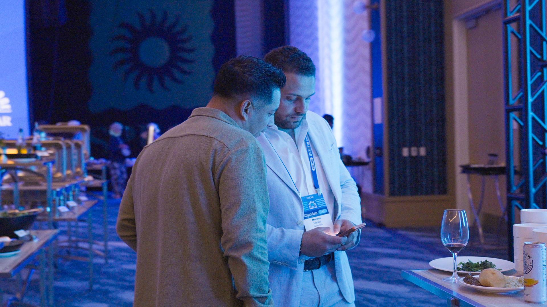 Two attendees reviewing something on a phone at the event